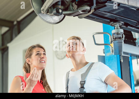 Erfahrener Mechaniker mit Blick auf das alte Fahrwerk sorgen Stockfoto