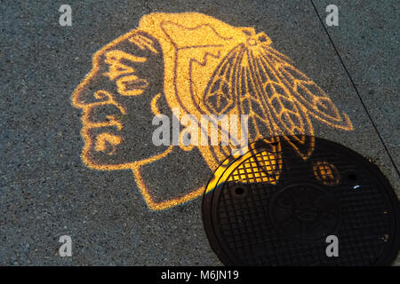 Das Logo der Chicago Hockeymannschaft der BlackHawks projiziert auf einem Bürgersteig hinter den BlackHawks in der Loop district, Chicago, Illinois. Stockfoto