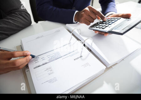 Zwei Unternehmer Berechnung von Rechnungen mit Rechner am Arbeitsplatz Stockfoto