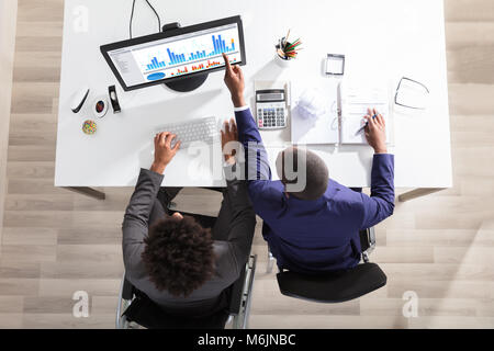 Hohe Betrachtungswinkel von zwei Geschäftsleute, die sich auf Graphen am Schreibtisch im Büro Stockfoto