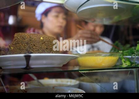 Banh MI Phuong Arbeitnehmer Zubereitung der traditionellen Speisen aus Zutaten, die in einem Glaskasten. Hoi An, Vietnam Stockfoto