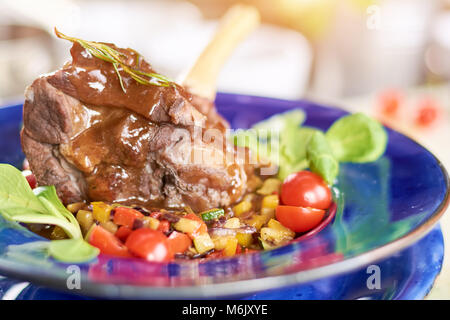 Langsam gekochte Lammkeule mit Gemüse. Stockfoto