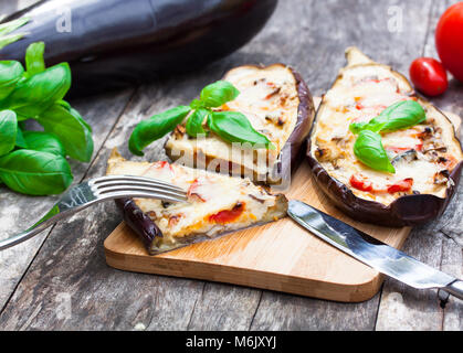 Gebacken, gefüllt mit Käse und Tomaten auf dem hölzernen Tisch Aubergine Stockfoto