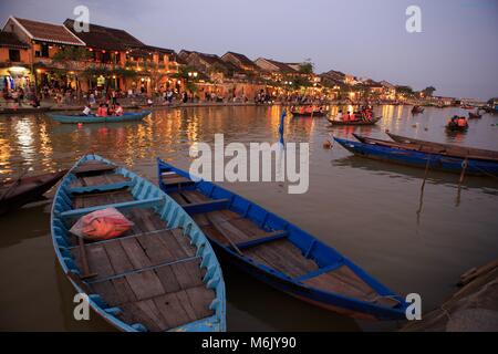 Holz- Boote auf dem Thu Bon Fluss gegenüber Bach Dang Street in der Altstadt von Hoi An, Vietnam Stockfoto