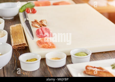 Lachs, Thunfisch, Aal auf Schneidebrett. Stockfoto