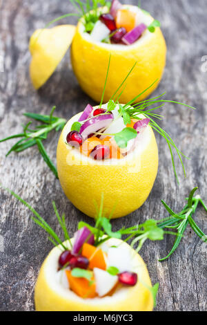 Gefüllte Zitronen mit vegetarischen Salat auf die alte Tabelle Stockfoto