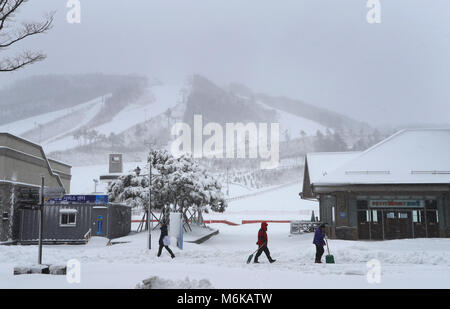 Pyeong Chang, Südkorea. 05 Mär, 2018. 05 März 2018, Südkorea, PyeongChang: Männer tragen Schnee schaufeln um die alpensia Center. Foto: Karl-Josef Hildenbrand/dpa/Alamy leben Nachrichten Stockfoto