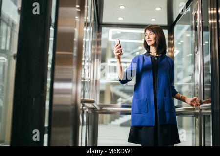 Nach Geschäftsfrauen in mit Smartphone Anzug Stockfoto