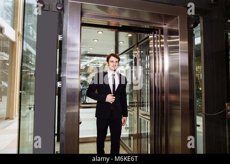 Im mittleren Alter Geschäftsmann mit Aktenkoffer aus Aufzug Stockfoto