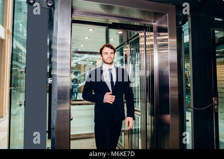 Im mittleren Alter Geschäftsmann mit Aktenkoffer aus Aufzug Stockfoto