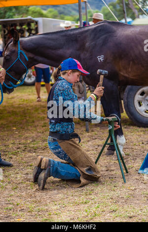 Jungen Konkurrenten einstellen ein Pferd Schuh für Ihr Pferd während der König der Bereiche Pferd beschlagen Wettbewerb in Murrurundi, NSW, Australien, 2018. Stockfoto