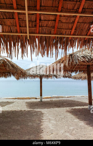 Schönen öffentlichen Sandstrand am Roten Meer in Eilat mit stro Schirme
