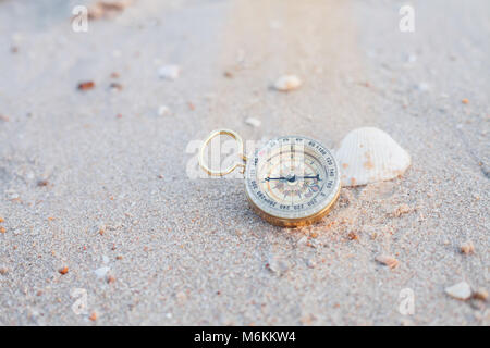 Pocket Compass auf Meer Strand Hintergrund. Stockfoto