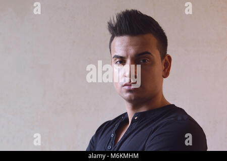 Dunkle moody Portrait von coolen jungen türkischen Mann mit stacheligen Haare Stockfoto