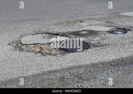 Beschädigte asphaltierte Straße mit Schlaglöchern in Melbourne, Australien Stockfoto