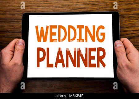 Hand schreiben Bildunterschrift Wedding Planner. Business Konzept für die Vorbereitung auf die Ehe geschrieben Tablet , Holz- Hintergrund mit Geschäftsmann Hand, f Stockfoto