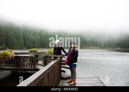 Asain Thai Frauen Mutter und Tochter reisen und im Waterfront Holzbrücke posiert am Mummelsee See bei Regen im Schwarzwald, Schwarzwald B Stockfoto