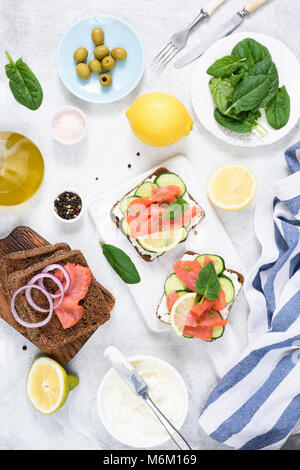 Vorspeise Lachs belegte Brote mit Frischkäse und Gurke. Mediterranes Frühstück. Ansicht von oben Stockfoto