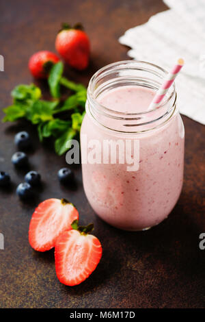 Pink Berry Smoothie in jar auf dunklem Hintergrund, Detailansicht, selektive konzentrieren. Gesunder Lebensstil, Detox, Diäten, sauber essen, vegan, Fitness, vegetar Stockfoto