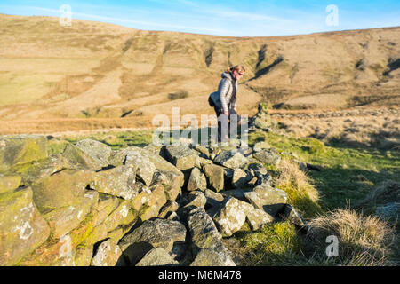 Weibliche Wanderer auf einem Pfad in den Goyt Valley Gegend des Peak District, mit den Katzen Tor/Shining Tor ridge in der Entfernung Stockfoto