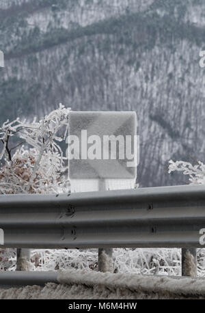 Schild Gefahr Kurve in Eis nach dem Regen abgedeckt Stockfoto