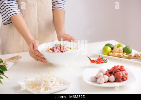 Köchin traditionelle vietnamesische Suppe pho bo mit Kräutern, Fleisch, Reis Nudeln Stockfoto