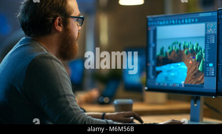 Männliche Spiel Entwickler arbeitet an einem neuen Design. Er ist stattliche bärtiger Mann mit Brille und arbeitet in ein kreatives Büro mit anderen talentierten Menschen. Stockfoto