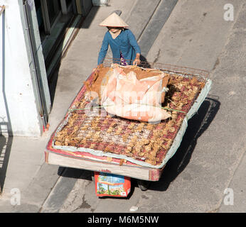 SAIGON, Vietnam, 18.Dezember 2017, vietnamesische Frau treibt einen Wagen mit großen alten Matratze. Das Leben auf der Straße an Saigon Stadt. Stockfoto