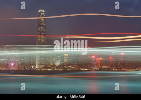 Leichte Spuren von einem vorbeifahrenden Boot Überfahrt Victoria Harbour Hong Kong in der Abenddämmerung. Stockfoto