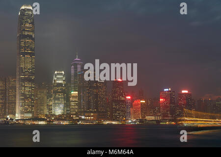 Leichte Spuren von einem vorbeifahrenden Boot Überfahrt Victoria Harbour Hong Kong in der Abenddämmerung. Stockfoto