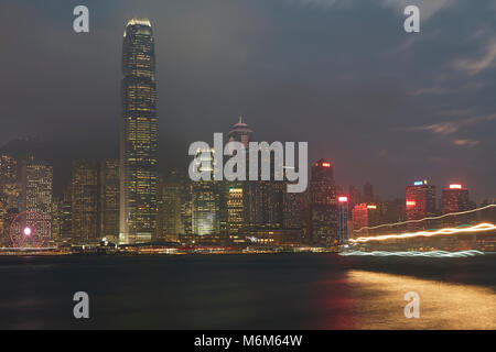 Leichte Spuren von einem vorbeifahrenden Boot Überfahrt Victoria Harbour Hong Kong in der Abenddämmerung. Stockfoto