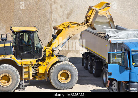 Radlader lädt ein Lkw mit Sand in einer Kiesgrube Stockfoto