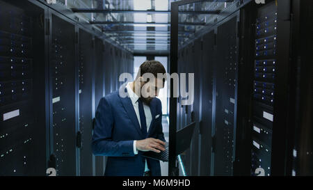 IT-Techniker im Data Center Server Rack Schrank Tür und verbindet es mit seinem Laptop. Führt das Diagnoseprogramm. Stockfoto