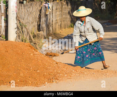 Dorfbewohner Handbuch Straßenbau arbeiten an der West Phwar sah Dorf, Bagan, Myanmar (Burma), Asien im Februar - die Frau, die Schaufeln Kies verpflichten sich, Stockfoto