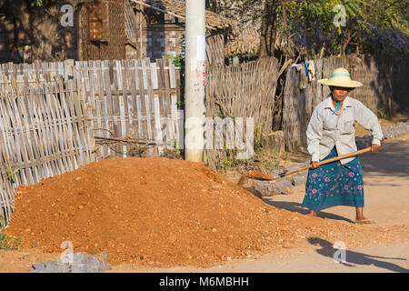 Dorfbewohner Handbuch Straßenbau arbeiten an der West Phwar sah Dorf, Bagan, Myanmar (Burma), Asien im Februar - die Frau, die Schaufeln Kies verpflichten sich, Stockfoto