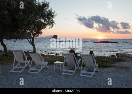 Liegestühle mit Blick auf den Sonnenuntergang am Nefeli Sunset Studios, Pollonia, Milos, Kykladen, Ägäis, Griechische Inseln; Griechenland; Europa Stockfoto