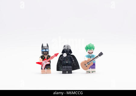 Lego Batman und Joker holding eine Gitarre mit Darth Vader singen. auf weißem Hintergrund. Stockfoto