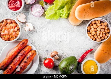 Zutaten für verschiedene hausgemachte Vegan Karotte Hot Dogs, mit gebratenen Zwiebeln, Avocado, Paprika, Pilzen, Tomaten und Bohnen, grauen Stein Hintergrund kopieren Stockfoto