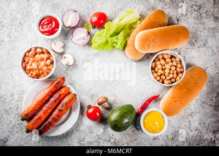 Zutaten für verschiedene hausgemachte Vegan Karotte Hot Dogs, mit gebratenen Zwiebeln, Avocado, Paprika, Pilzen, Tomaten und Bohnen, grauen Stein Hintergrund kopieren Stockfoto
