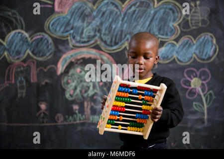 Ein Junge setzt auf abacus Stockfoto