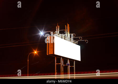 Leere Anschlagtafel auf Nacht city street, mockup. Leichte Spuren von vorbeifahrenden Autos durch die Straßen der Nacht Stadt. Stockfoto