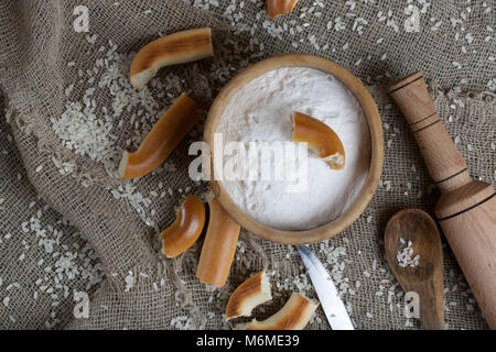 Reis Mehl in eine olivenholz Platte auf einem Sack. Stockfoto