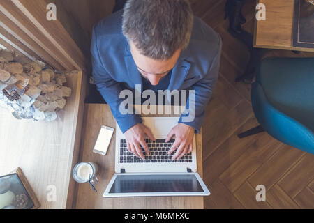 Hohe Betrachtungswinkel der Mann bei der Arbeit am Laptop im Cafe Stockfoto