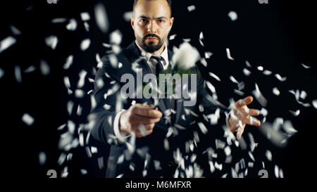 Professioneller Zauberer führt Blume (Rose) Bud Verschwinden und Erscheinen spektakulärer Trick. Der Hintergrund ist schwarz. Stockfoto