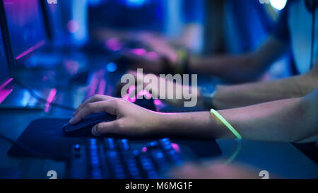 Close-up Auf der Reihe der Gamer Hände auf einer Tastatur. jpgs, Aktiv das Drücken von Tasten, Spielen MMO-Spiele Online. Hintergrund Leuchtet mit Neonlicht. Stockfoto