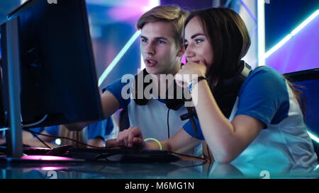 Junge und Mädchen Spieler aktiv Denken / Diskussion Spiel Strategie / Taktik, Sie sind im Internet Café oder auf Cyber Games Turnier. Stockfoto