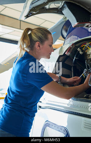 Weibliche Aero Engineer, der an Helikopter im Hangar Stockfoto