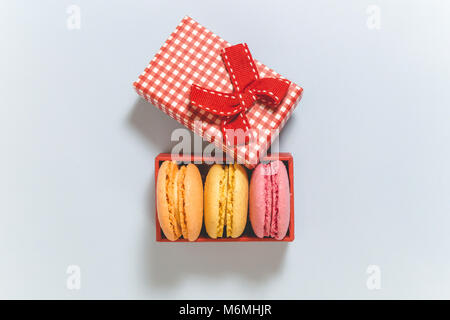 Macarons in Geschenkbox auf blauem Hintergrund hoher Blickwinkel betrachten. Minimalen Begriff Stockfoto