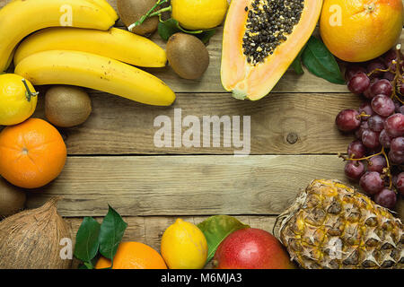 Rahmen mit Kopieren aus frischen tropischen und Sommer saisonale Früchte Ananas Papaya Mango Coconut Orangen, Kiwi, Bananen, Zitronen Pampelmusen und Grapefruits auf Holz Bac Stockfoto