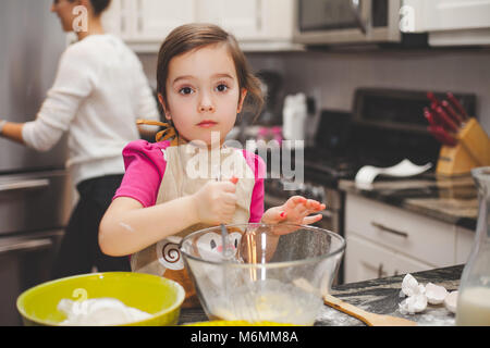 Glückliche Familie in der Küche, die Mutter und Tochter kochen Apfelkuchen, Mixen von Teig Stockfoto